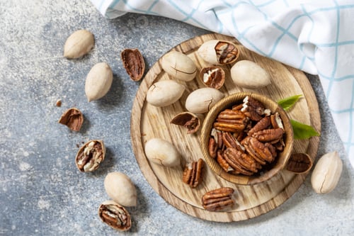 Preview: Bowl with pecan nuts on a stone table.