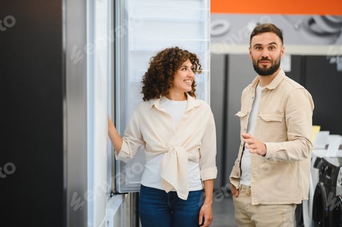 Preview: Couple choosing refrigerator in electronics store discussing features