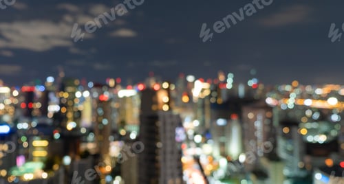 Preview: Bokeh of skyscraper buildings in city with lights, Blurry photo at night time. Cityscape background