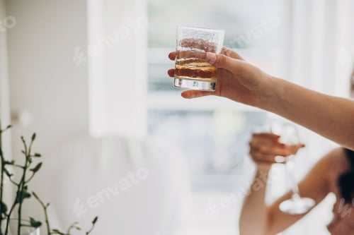 Preview: Guests holding glass with whiskey and toasting at wedding reception