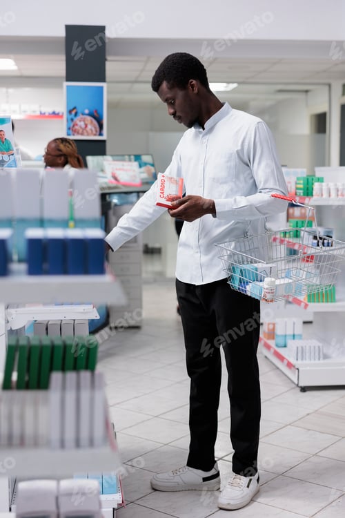 Preview: African american man checking heart nutritional supplements in drugstore