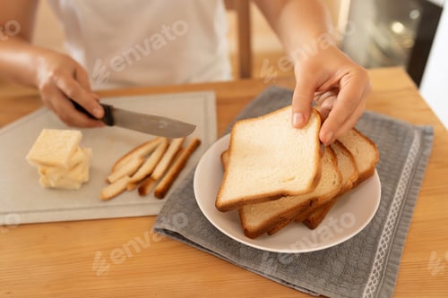 Preview: women's hands slicing bread with a knife on a board