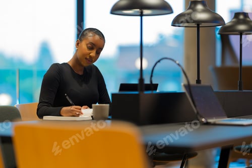 Preview: Woman writing notes in modern office