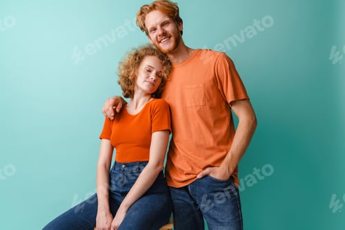 Preview: Young happy redhead couple smiling and hugging at camera
