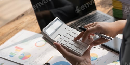 Preview: Business woman using calculator to calculate financial report, working at office with laptop