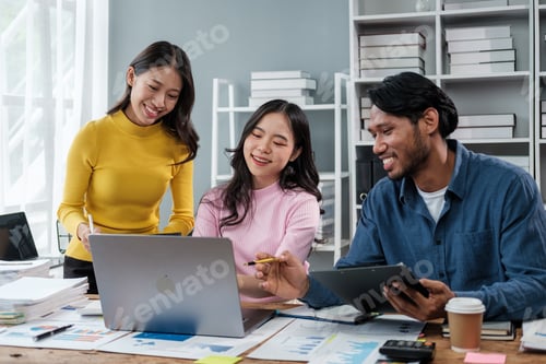Preview: Group of young Asian business people brainstorming, looking at laptop computer.