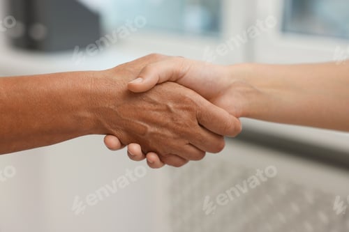 Preview: Cooperation. Women shaking hands in office, closeup