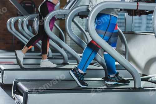 Preview: low section of women training on treadmills