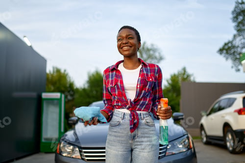 Preview: Woman poses with spray and a rag, car wash station
