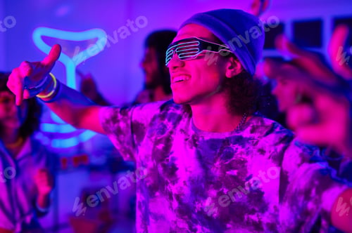 Preview: Young smiling man in neon eyeglasses and casualwear dancing at party