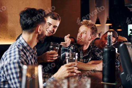 Preview: Group of people together indoors in the pub have fun at weekend time