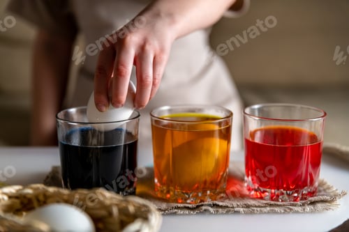 Preview: girl at home in the kitchen dyes eggs for Easter