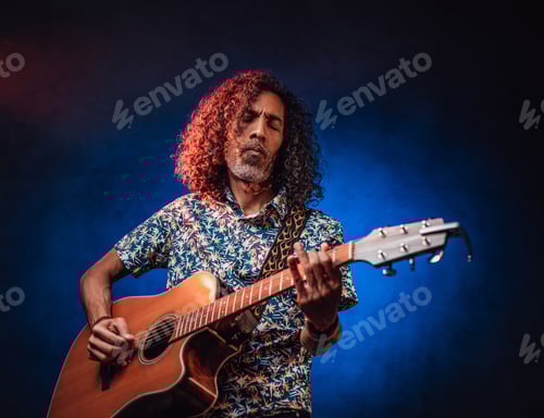 Preview: Middle aged hispanic man musician playing guitar on a dark illuminated by blue and red light