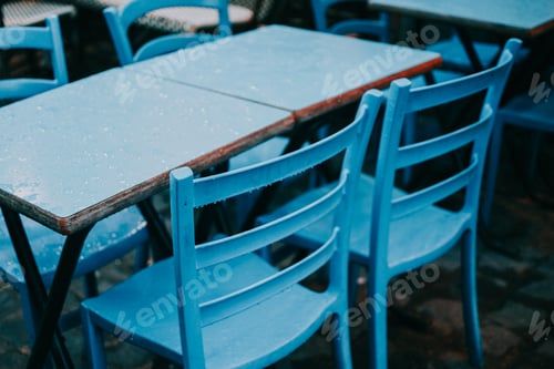 Preview: some blue chairs a brown table and some plants in a window