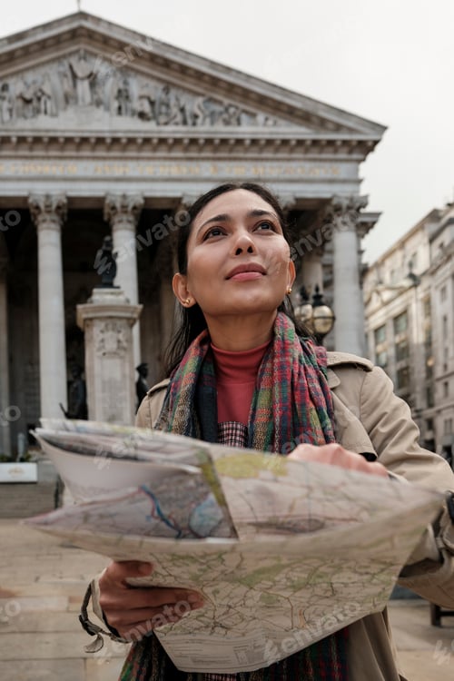 Preview: Woman tourist holding map looking at london architecture