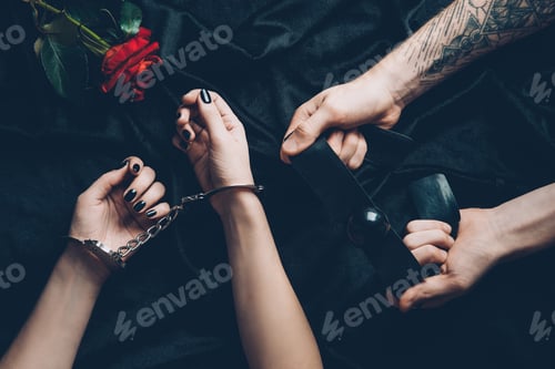 Preview: cropped shot of couple with handcuffs and gag above black fabric with rose flower