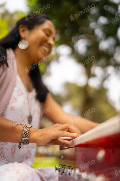 Preview: Happy woman playing a song on her harmonium in the park