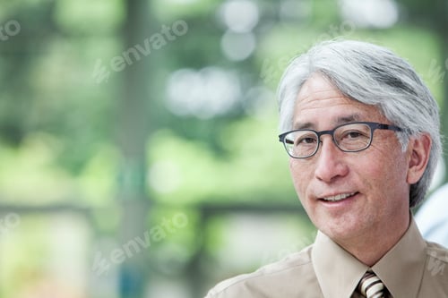 Preview: A portrait of an Asian businessman in a convention center setting.