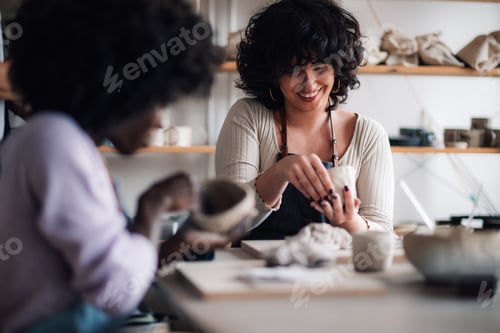 Preview: Interracial pottery course attendees making earthenware on class.