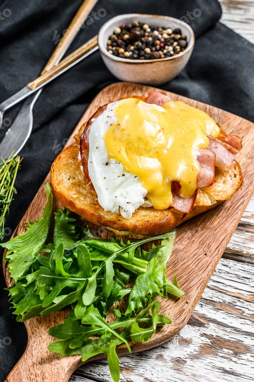 Preview: Brioche sandwich with bacon, egg Benedict and hollandaise sauce. White background. Top view