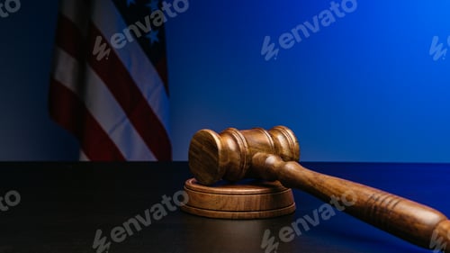 Preview: Gavel on court desk on background of USA flag