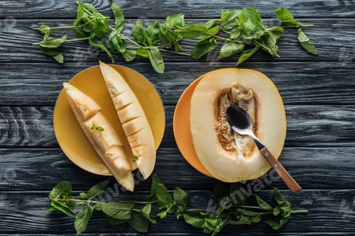 Preview: top view of fresh ripe sweet melon with spoon and fresh mint on wooden surface