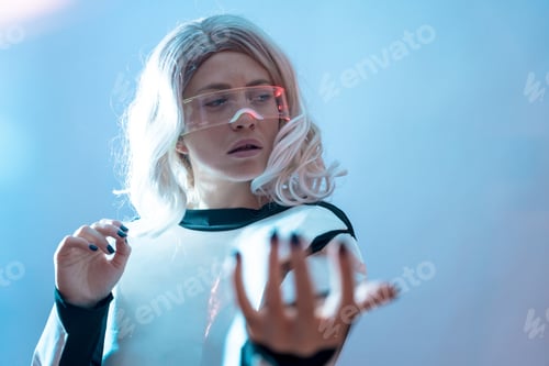 Preview: Woman with the illuminated futuristic glasses white hair, virtual reality with looking to the sides