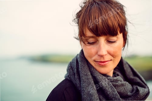 Preview: Smiling woman looking down at beach