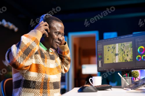 Preview: African american videographer works on editing film footage at home