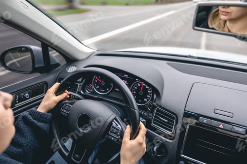 Preview: Woman driver's hands on a car steering wheel.