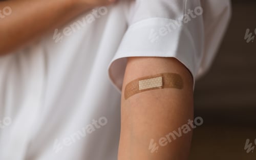Preview: Closeup image of a woman with adhesive bandage, medical plaster, band aid on her arm