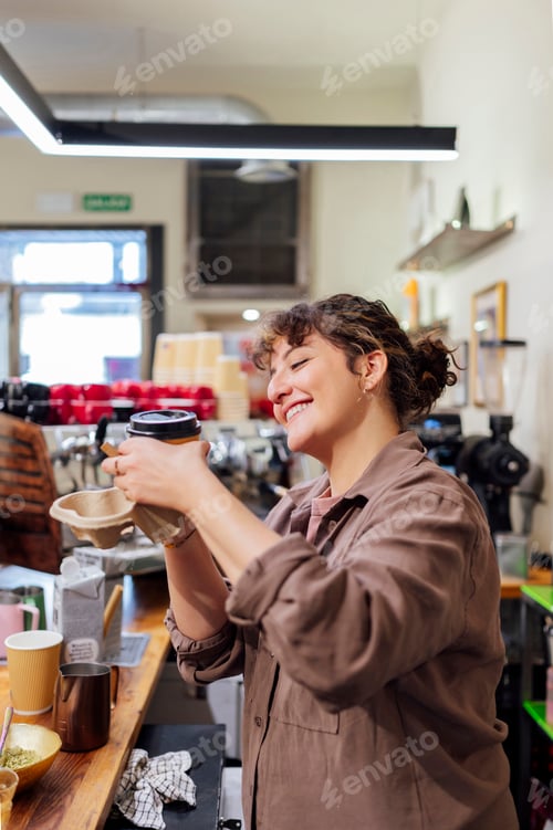 Preview: Barista preparing takeaway coffee smiling in a coffee shop