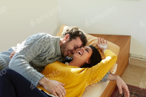 Preview: Mid adult couple on window seat face to face laughing