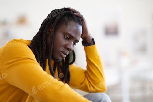 Preview: Closeup Portrait Of Depressed African American Guy Sitting At Home