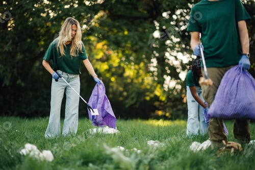 Preview: Volunteers collecting trash in public park wearing matching shirts