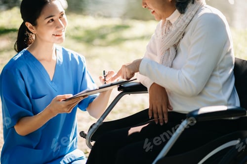 Preview: Elderly asian senior woman on wheelchair with Asian careful caregiver and encourage patient, walking