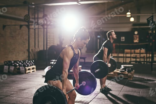 Preview: Fit muscular people lifting barbells in gym