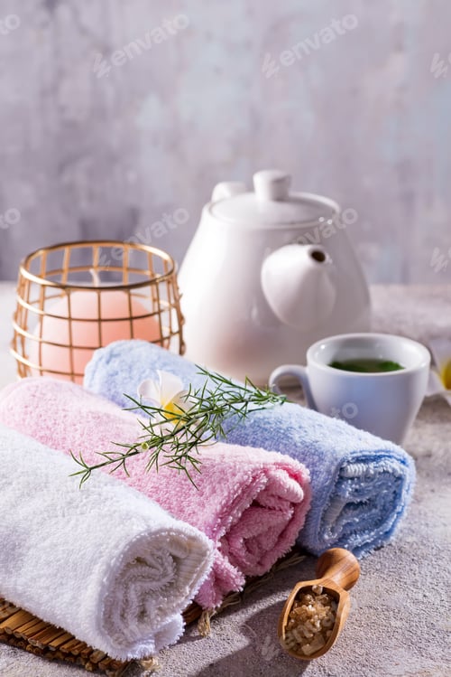 Preview: Color towels with flower, spoon of salt, on bamboo mat, bath spa treatment and green tea on stone