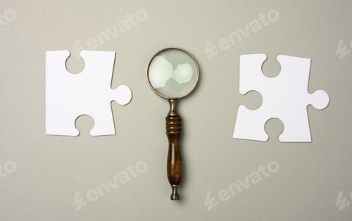Preview: Puzzles around a magnifying glass on a gray background.