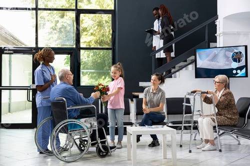 Preview: Child brings flowers to disabled senior patient at clinic hallway