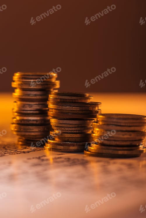 Preview: selective focus of coins stacks on text document with blurred background