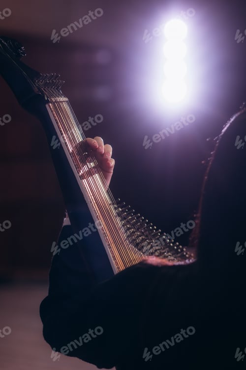 Preview: Musician Playing Harp Under Dramatic Lighting in a Performance Setting