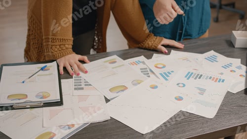 Vista previa: Close up of colleagues checking papers with data rate charts