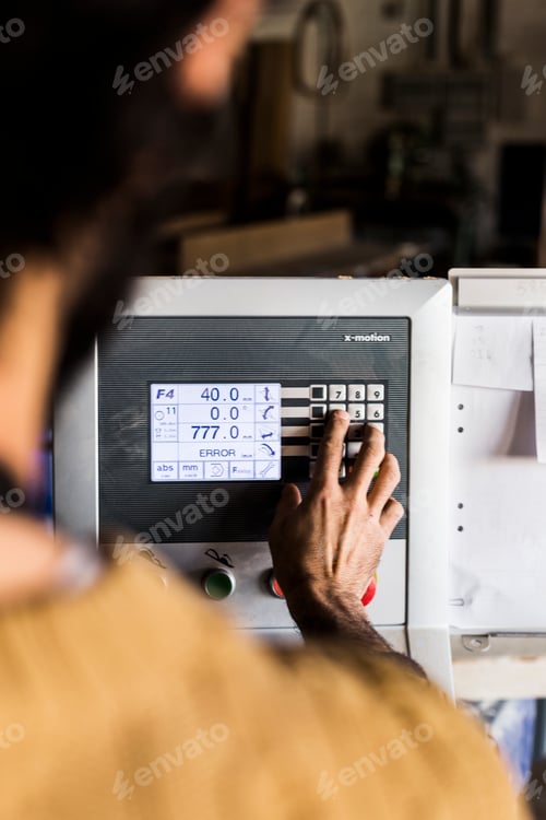 Vista previa: Mano de carpintero usando el monitor en una sierra de mesa en el taller