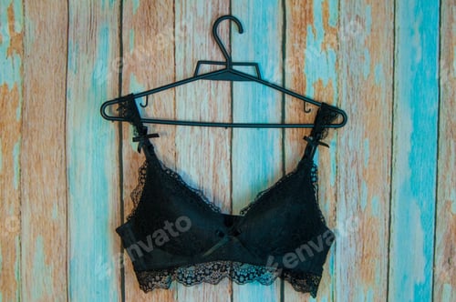 Black Bra on Hanger Against Patterned Wall