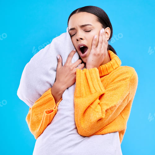 Preview: Tired woman, pillow and yawn in studio with exhausted face, and ready to sleep by blue background.