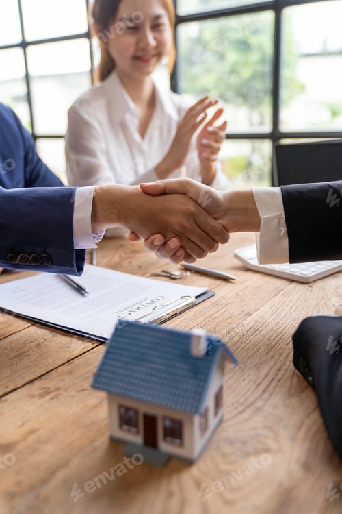 Preview: Estate agent shaking hands with customer after contract signature after completing negotiations to b
