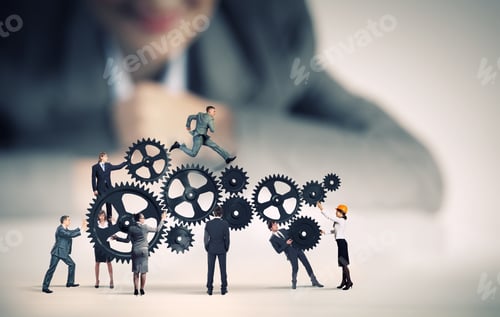 Preview: Businesswoman Looking At Team Of Businesspeople In Miniature