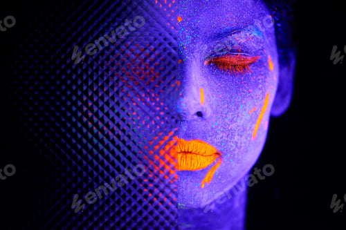 Preview: The beauty of the surreal. Shot of a young woman posing with neon paint on her face.