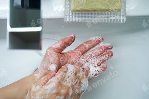 Preview: The process of washing hands with natural soap over the sink.